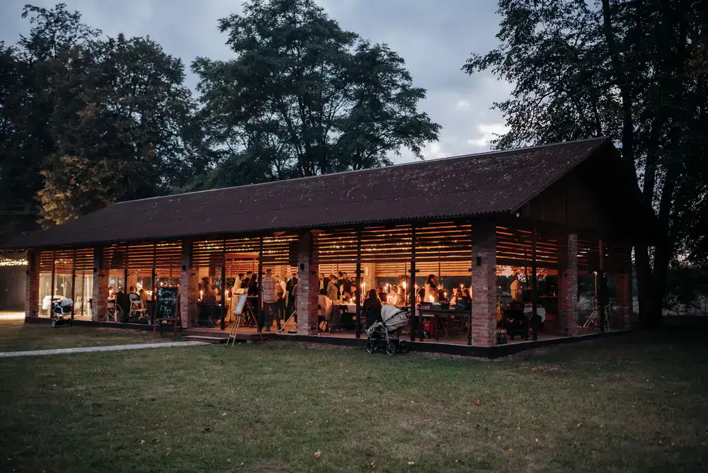 Guests enjoying pizza near the van at an evening event