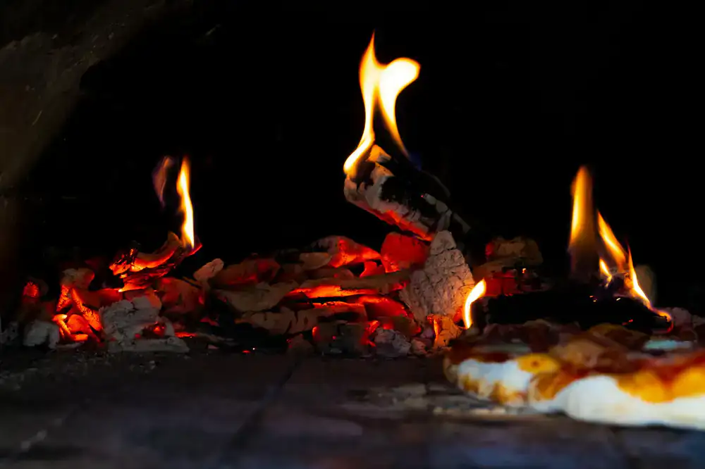 Wood-fired oven glowing hot inside the mobile pizza van