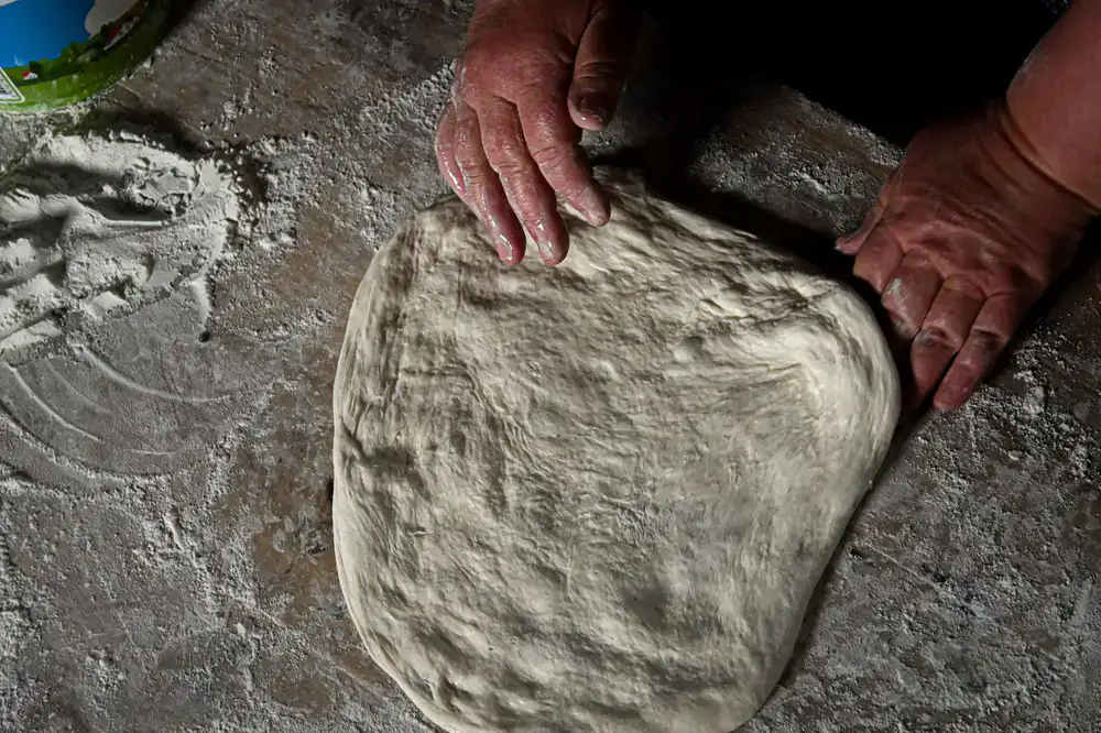 Hand stretching pizza dough