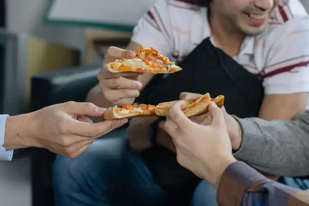 Guests enjoying pizza slices near the food van